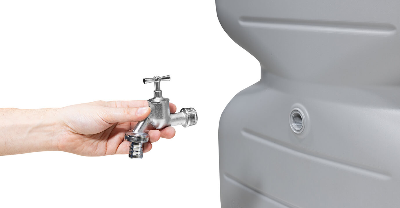 une main qui tient un robinet près d'une cuve aérienne réservoir cubus gris clair Sotra'O